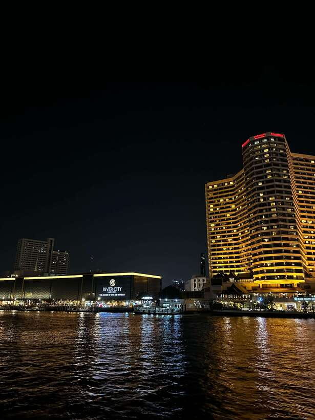 Bangkok: Chao Phraya River Cruise with Indian Buffet Dinner - Riding the Chao Phraya at night, with big landmark payoff
